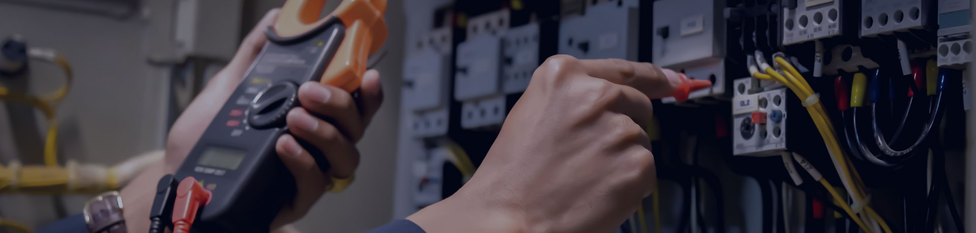 Un ingénieur électricien mesure la tension et la puissance de la ligne électrique dans un cabinet de contrôle