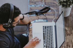 Un jeune assis sur une chaise en regardant son ordinateur portable