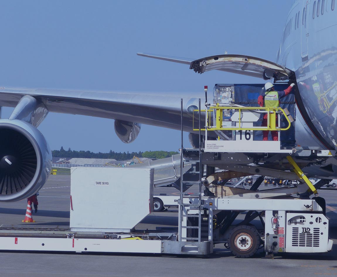 homme en train de charger un avion de fret avec des marchandises