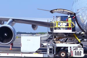 homme en train de charger un avion de fret avec des marchandises