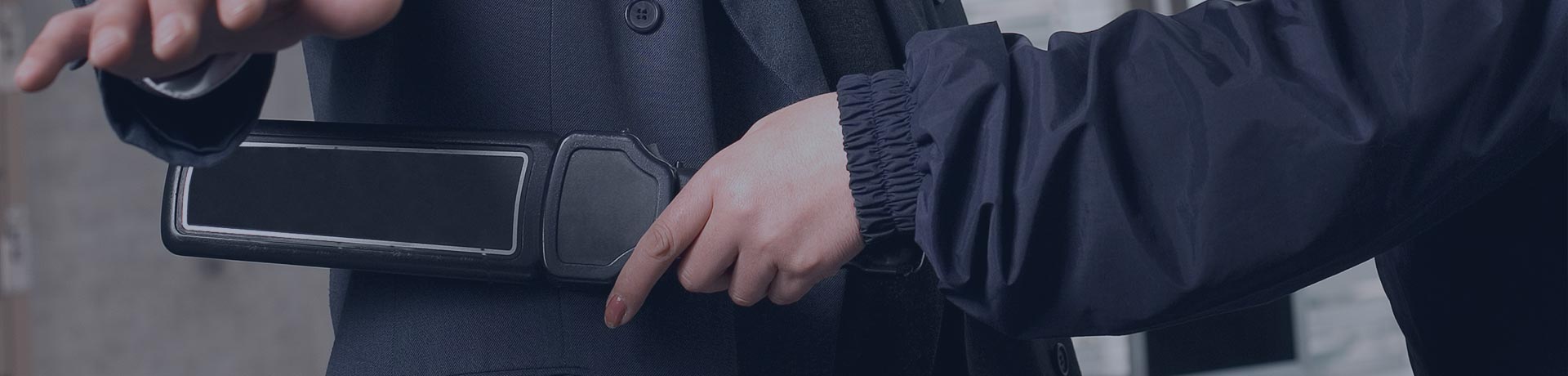 homme en train de passer un détecteur à métaux sur un passager