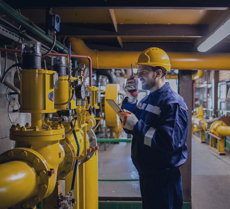 Photo Heating plant gas pipe installation. Industrial or power plant worker checking gas consumption.