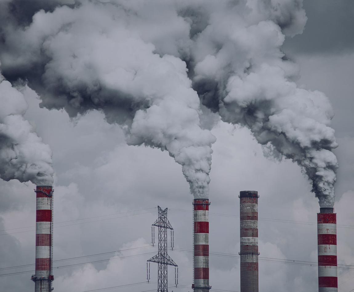 smoke escaping from several factory chimneys