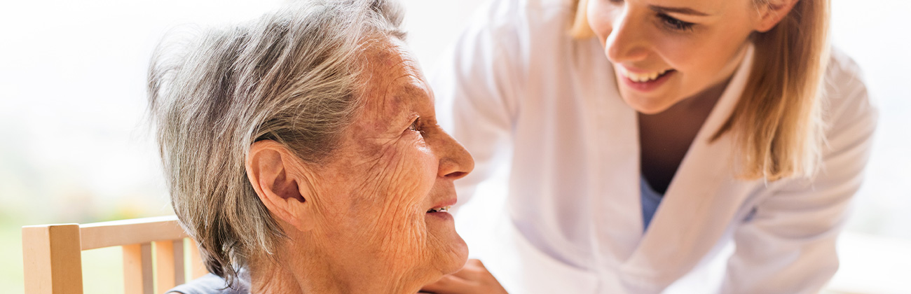 Une aide soignante en train d'aider une personne âgée