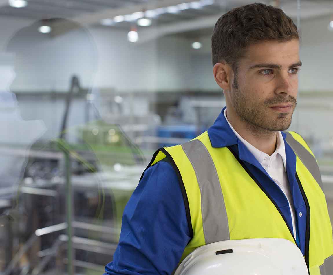 Travailleur debout près d'une fenêtre dans une usine