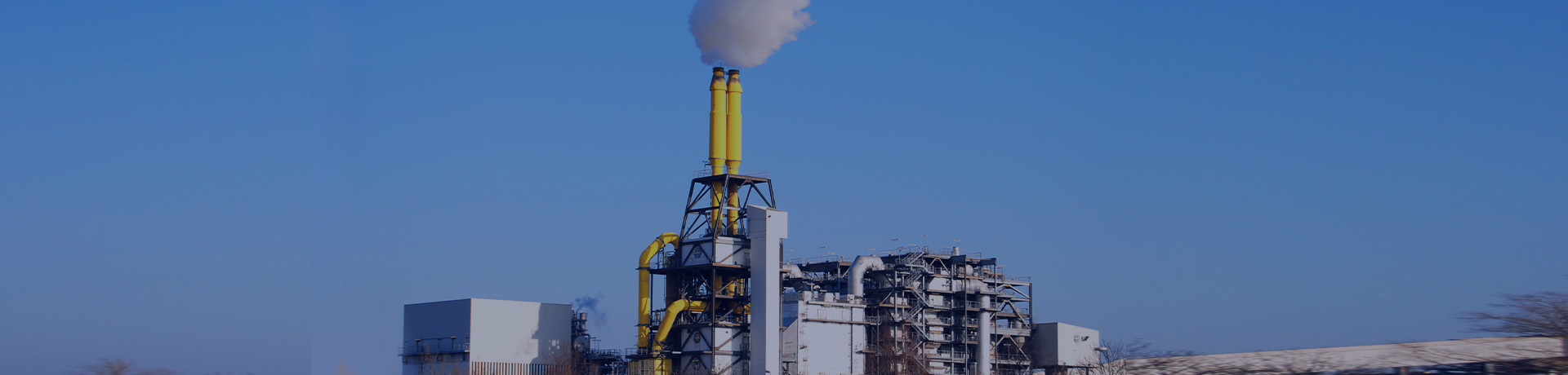 Usine d'incinération des déchets avec cheminées jaunes d'où sort de la fumée