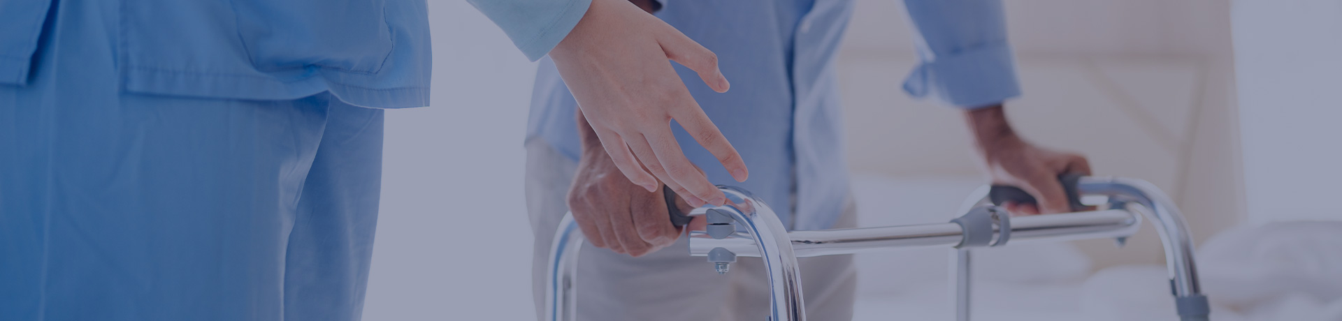 Jeune infirmière aidant un vieil homme handicapé à marcher à l'aide d'un déambulateur dans la chambre.