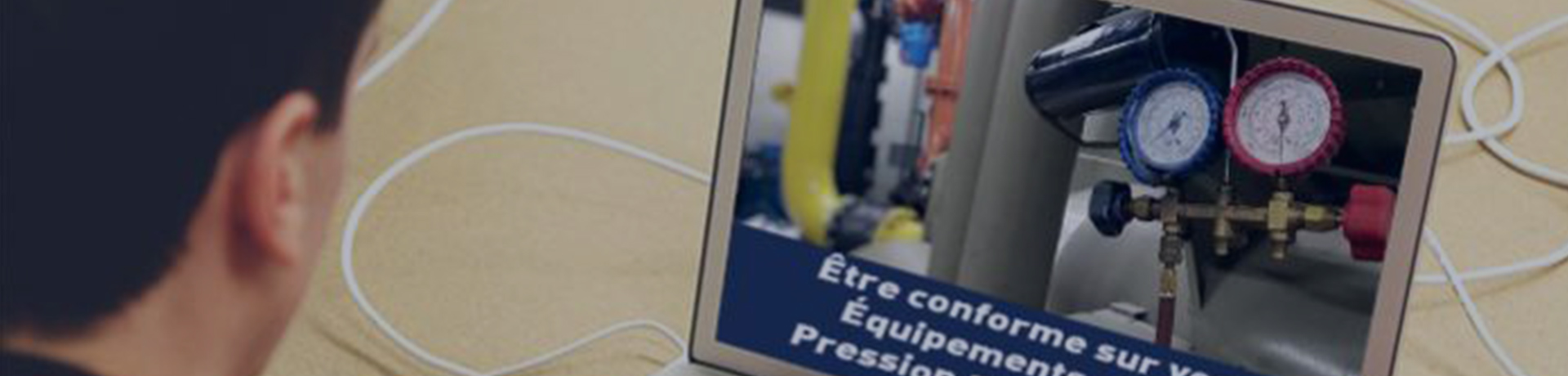 Un homme devant son ordinateur en train de regarder une photo d'un équipement sous pression