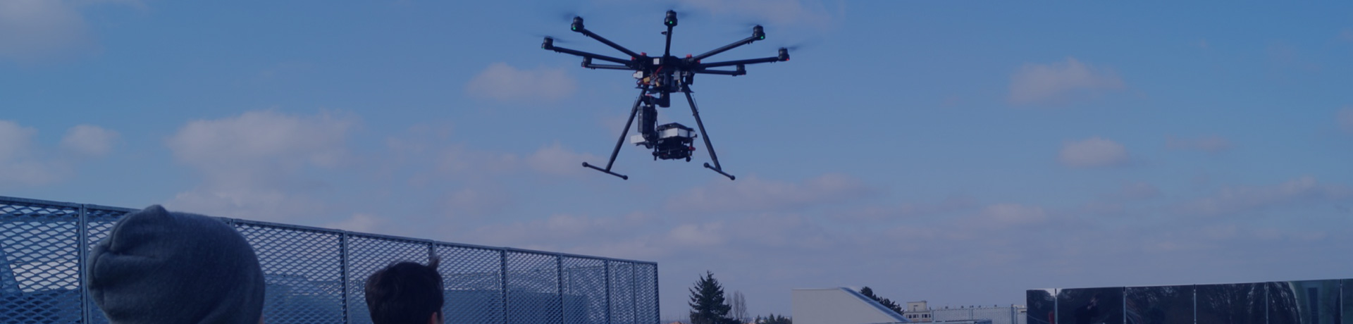 Deux collaborateurs Apave regardent un drone voler 