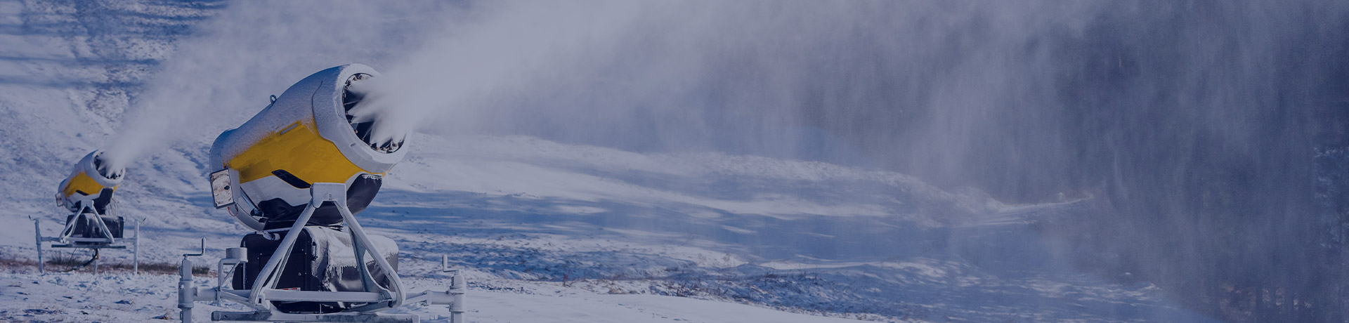Canons à neige qui enneigent une piste de ski