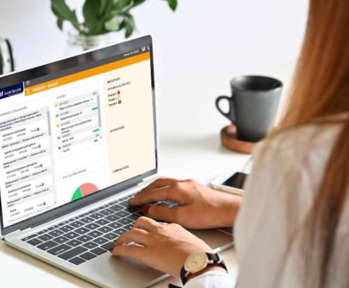 Une femme travaille sur un ordinateur portable affichant une interface utilisateur web.