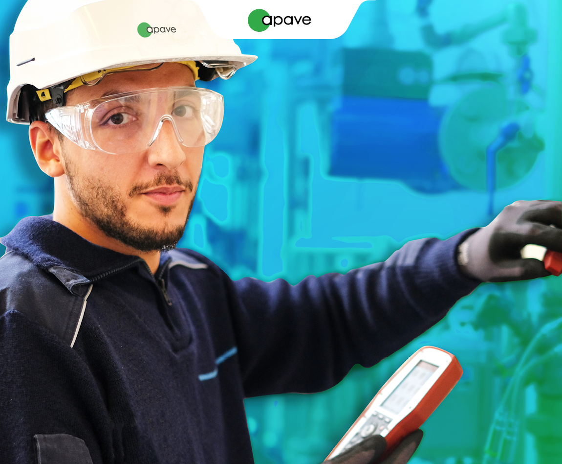 Un homme porte un casque blanc avec le logo Apave et tient une tablette dans ses mains