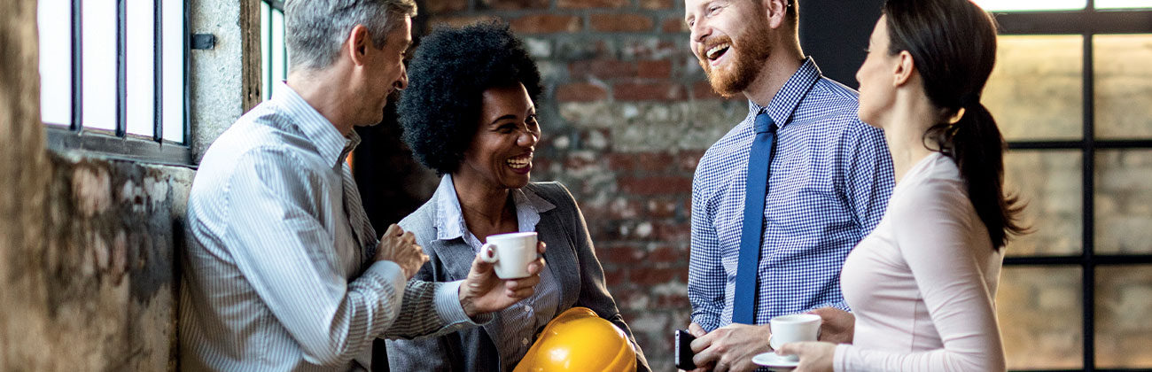 Groupe de collègues de travail joyeux en train de communiquer lors d'une pause café