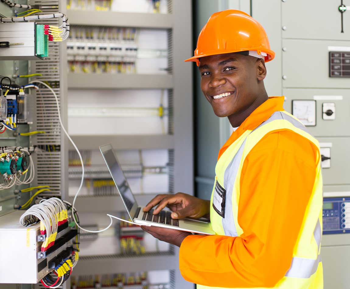 Ouvrier utilisant un ordinateur portable devant un compteur électrique 