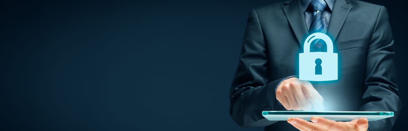  Un homme en costume manipule une tablette numérique d'où émane un cadenas lumineux, symbolisant la cybersécurité et la protection des données.