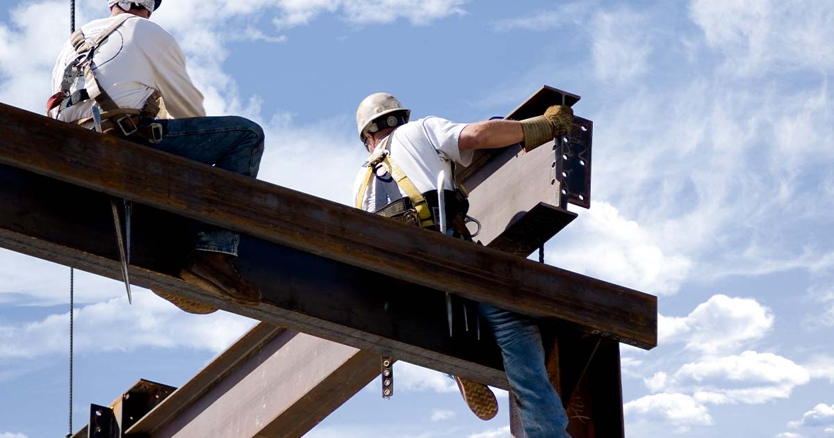 Deux ferronniers au sommet du squelette d'un bâtiment moderne