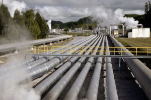 Alignement de larges pipelines industriels métalliques avec émissions de vapeur en arrière-plan.