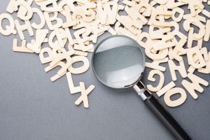 Loupe sur des lettres en bois.