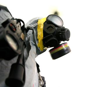 Un masque à gaz avec un filtre est visible de profil, faisant partie d'un équipement de protection individuel pour risques chimiques.