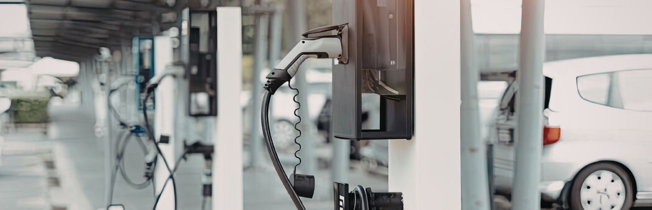 Alignement de bornes de recharge pour véhicules électriques dans un parking couvert.