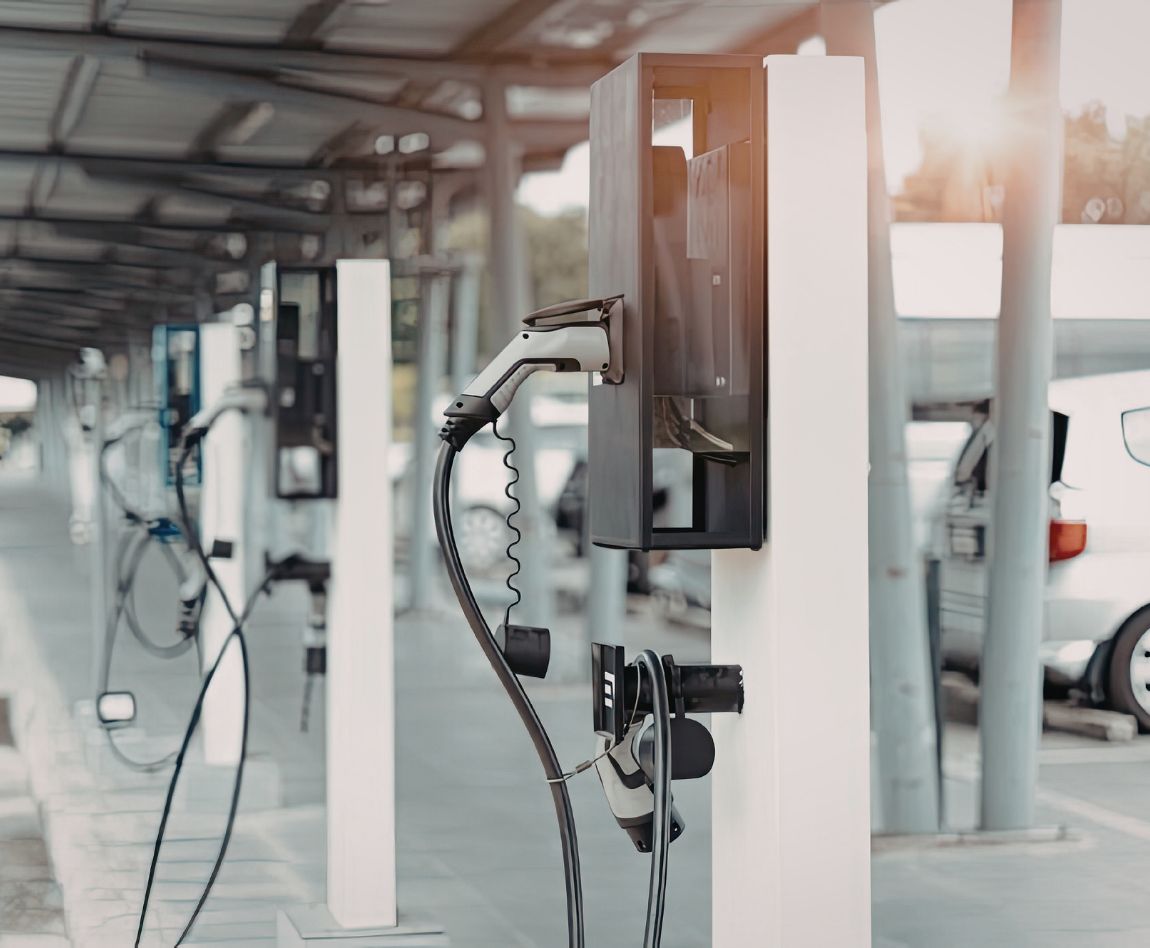 Alignement de bornes de recharge pour véhicules électriques dans un parking couvert.