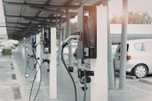Alignement de bornes de recharge pour véhicules électriques dans un parking couvert.
