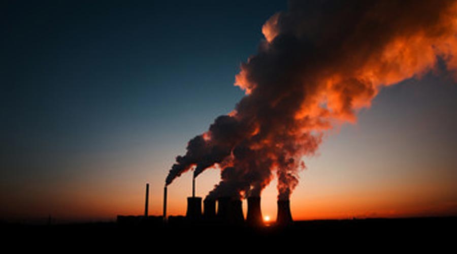 rilascio di fumo di fabbrica nell'atmosfera su un sole che tramonta