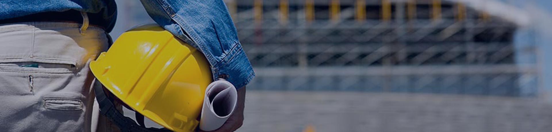 man wearing a hard hat in front of a construction site
