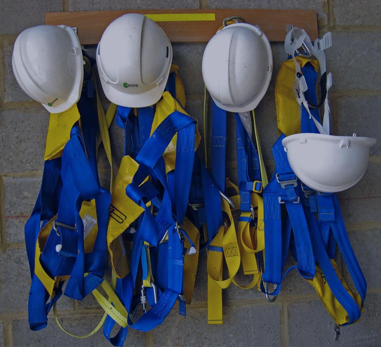 casques et équipements de chantier accrochés dans un vestiaire