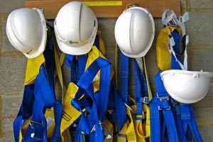 casques et équipements de chantier accrochés dans un vestiaire
