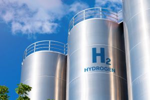 Cuves de stockage d'hydrogène (H2) en métal, sous un ciel bleu, représentant les infrastructures pour l'énergie hydrogène.