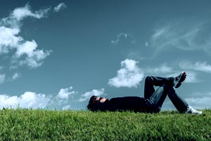 homme allongé dans l'herbe en train de réfléchir