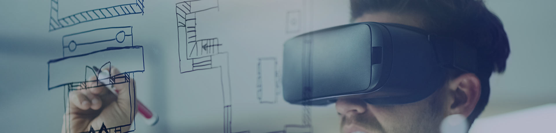 A man with a virtual reality headset writing on a board