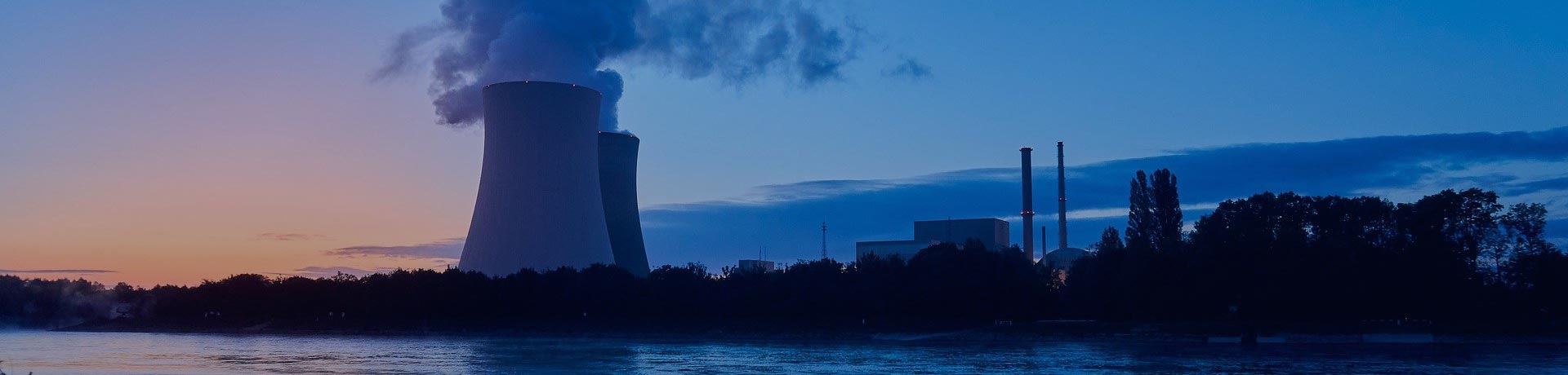 centrale nucléaire au bord de l'eau sur fond de coucher de soleil