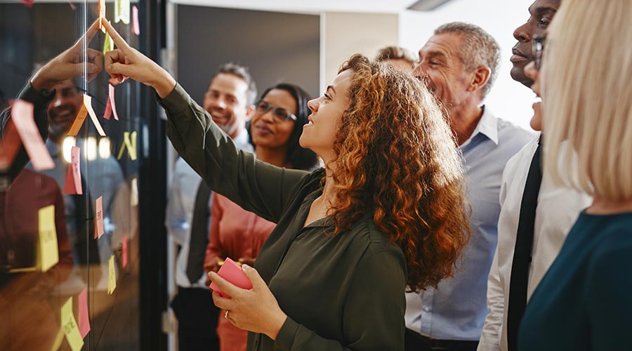 Une groupe de personnes en train de coller des postits sur un tableau