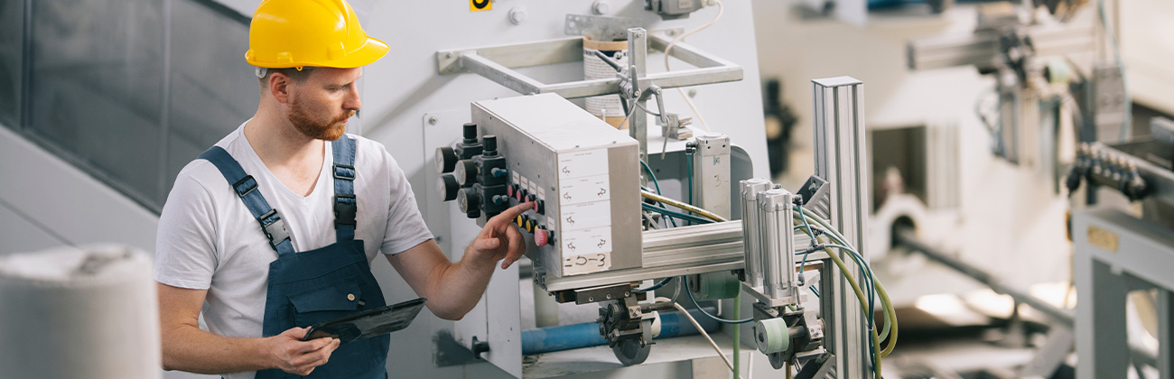 Homme casqué travaillant dans une usine.