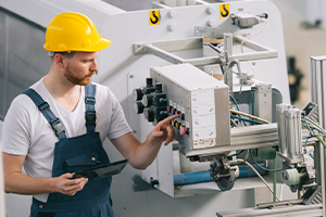 Homme casqué travaillant dans une usine.