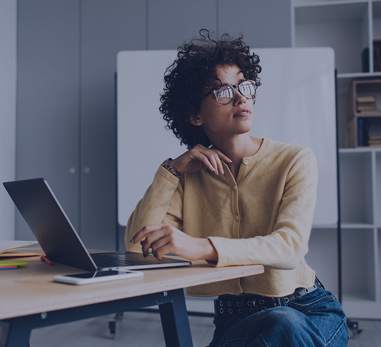 Une femme regarde par la fenêtre dans un open space de travail