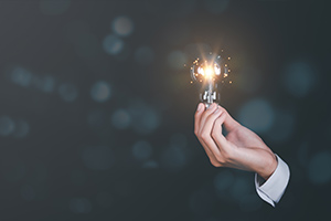 Main en costume tenant une ampoule